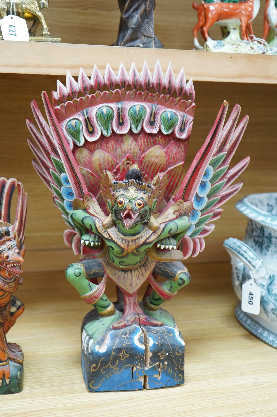 A Balinese painted and carved wood sculpture of Garuda, together with a smaller similar carving, largest 46cm high
